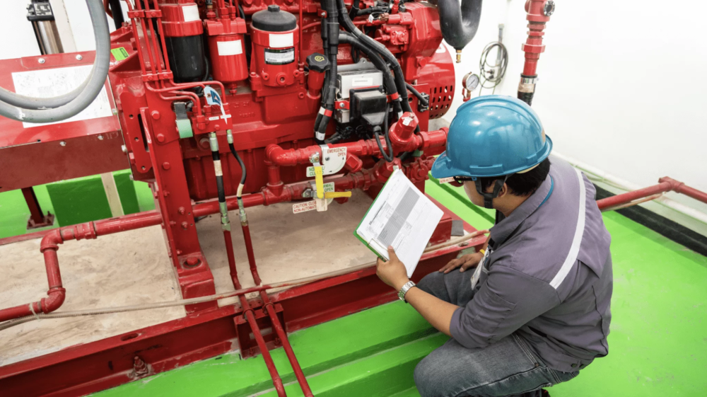 worker checking fire extinguisher equipment